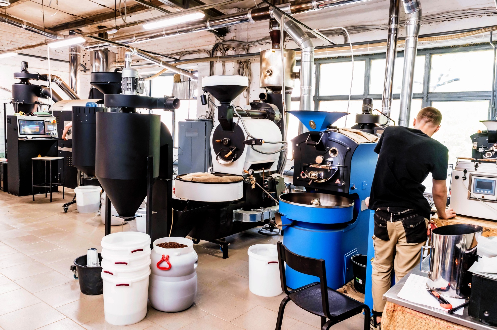 Coffee pouring from roaster machine to cooling cylinder.