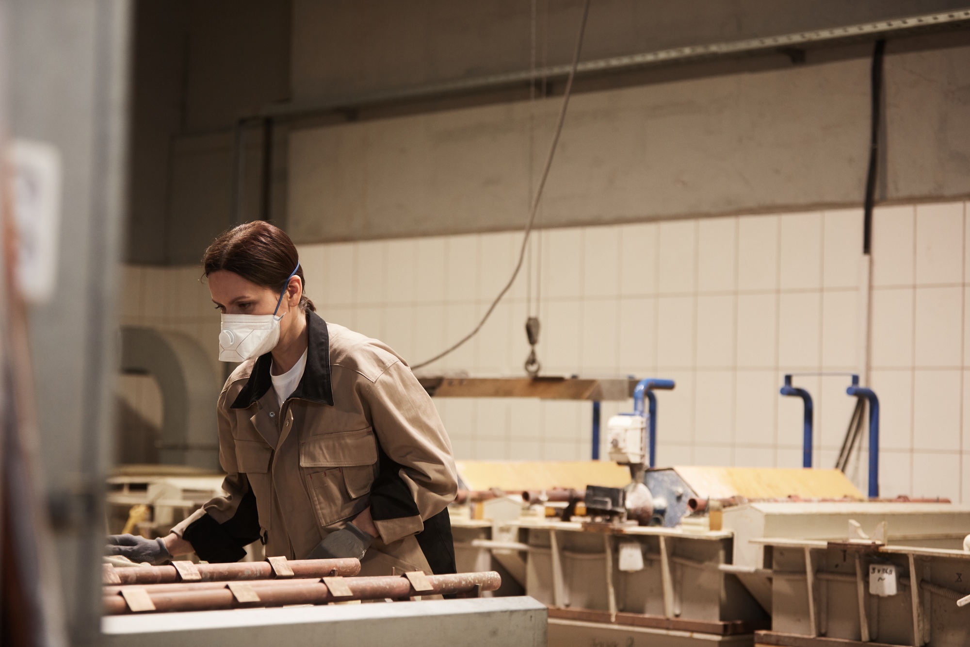 Examining processed tubes in industrial workshop